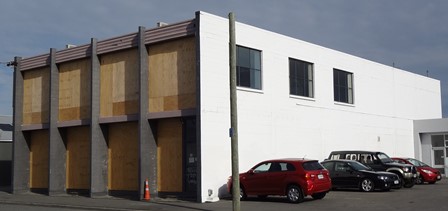 A building with cars parked in frontDescription automatically generated with medium confidence